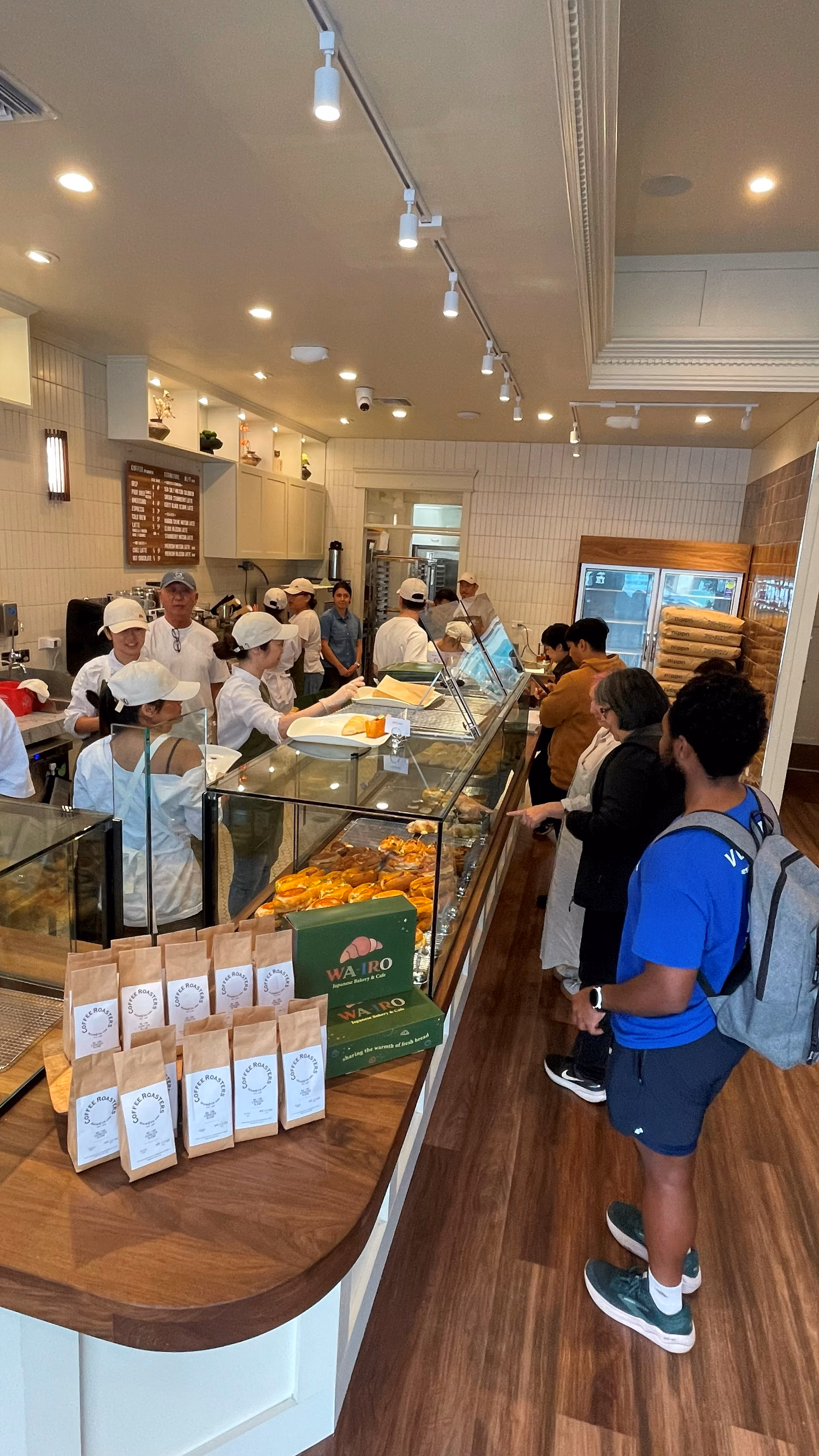 A quiet moment along the bakery counter with pastry cases and hanging pendant lights.